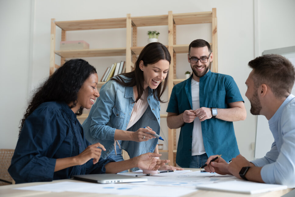 Eine Gruppe von vier jungen Professionals arbeitet gemeinsam an einem Thema. 